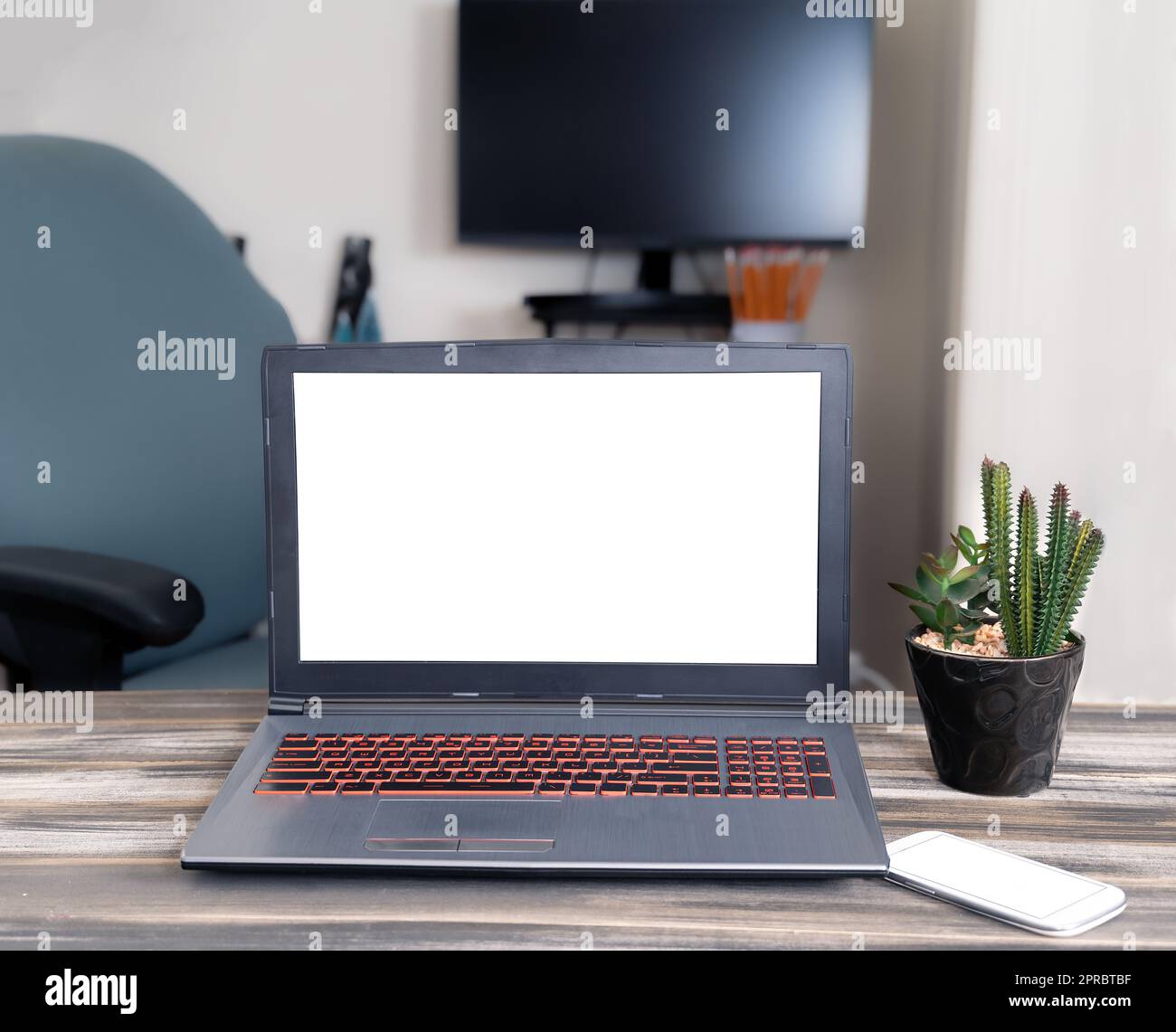 Modell eines Laptops, Mobiltelefon mit leerem Bildschirm auf einem Holztisch im Büro. Speicherplatz kopieren Stockfoto