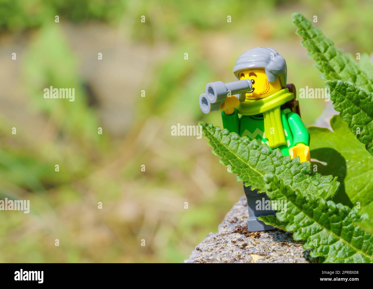 LEGO Minifigur mit Rucksack und Fernglas Wandern in der Natur und Vogelbeobachtung aktive Senioren. Besseres Altern, Abenteuerreisen, Fernweh-Konzept. Stockfoto