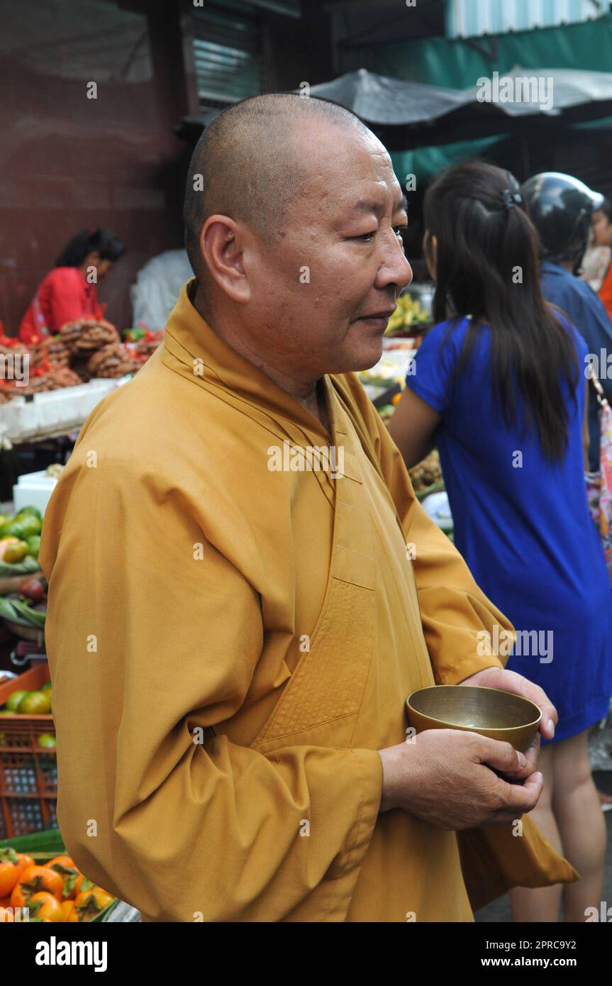 Ein thailändischer buddhistischer Mönch segnet die Einheimischen und empfängt Almosen im Rahmen eines morgendlichen Rituals. Foto in Bangkok, Thailand. Stockfoto