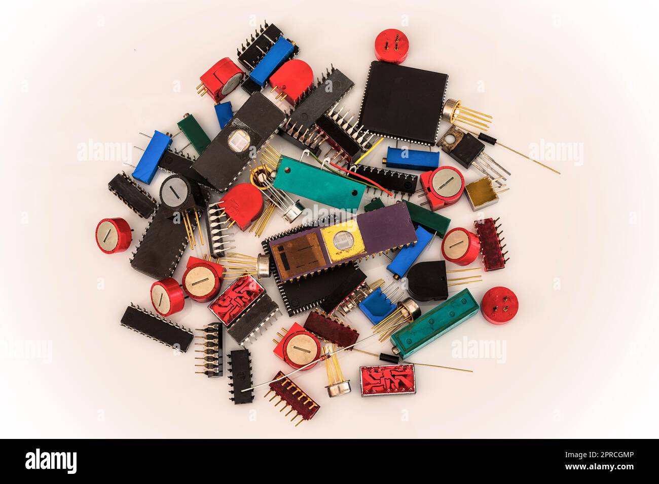 Eine Gruppe alter elektronischer Bauteile stapelt sich auf weißem Hintergrund. Stockfoto