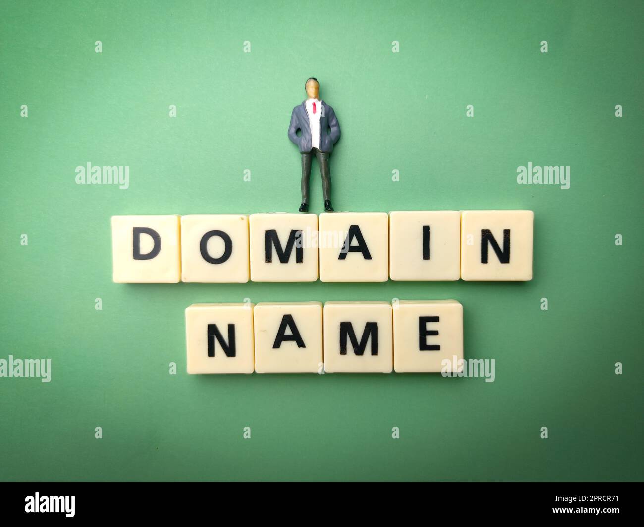 Miniatur-Menschen und Spielzeugwort mit dem Wort DOMÄNENNAME Stockfoto