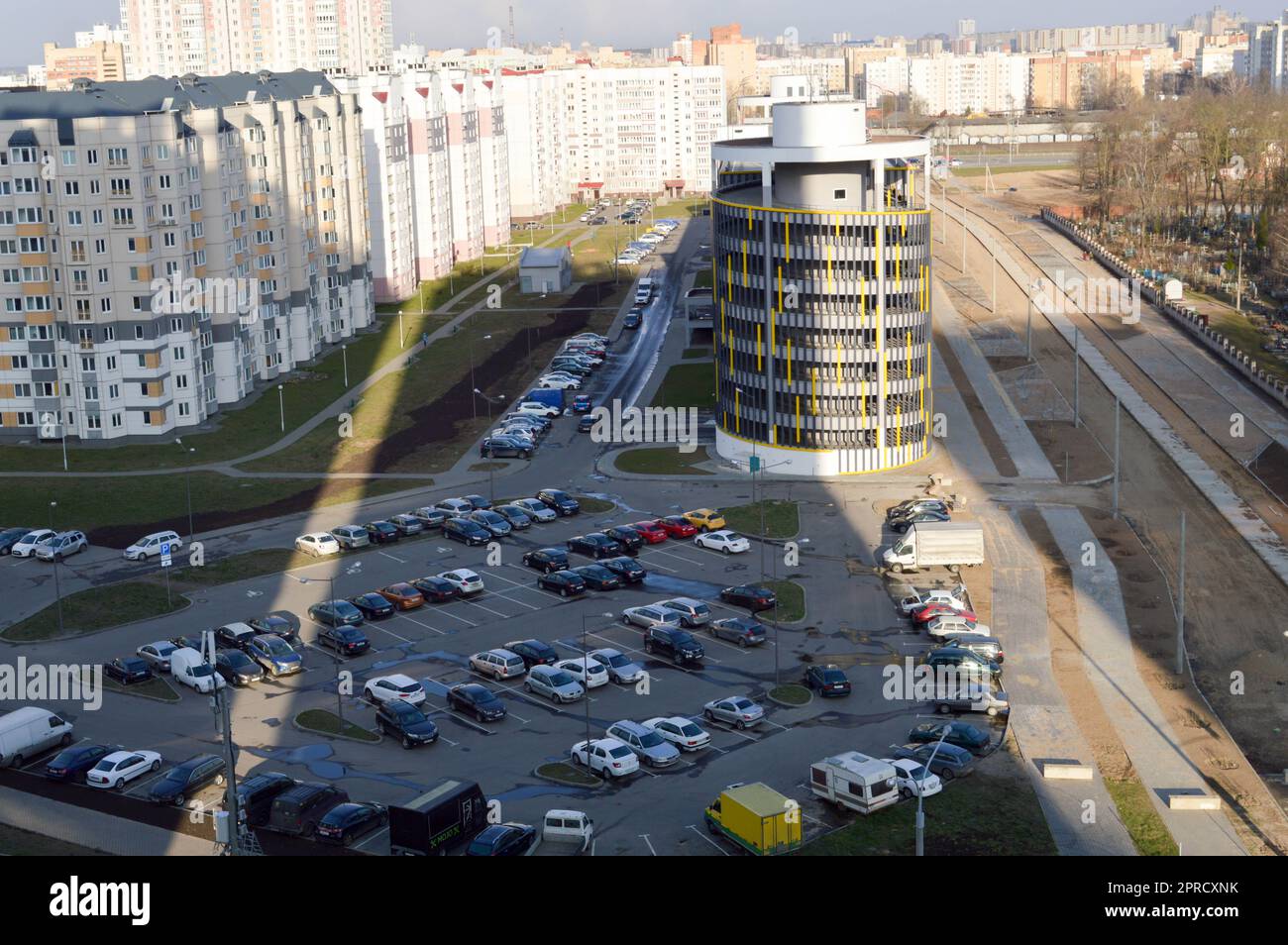Blick von der Spitze eines großen offenen Parkplatzes und Parkhauses auf mehreren Ebenen in einem Wohngebiet der Großstadt der Metropole. Stockfoto