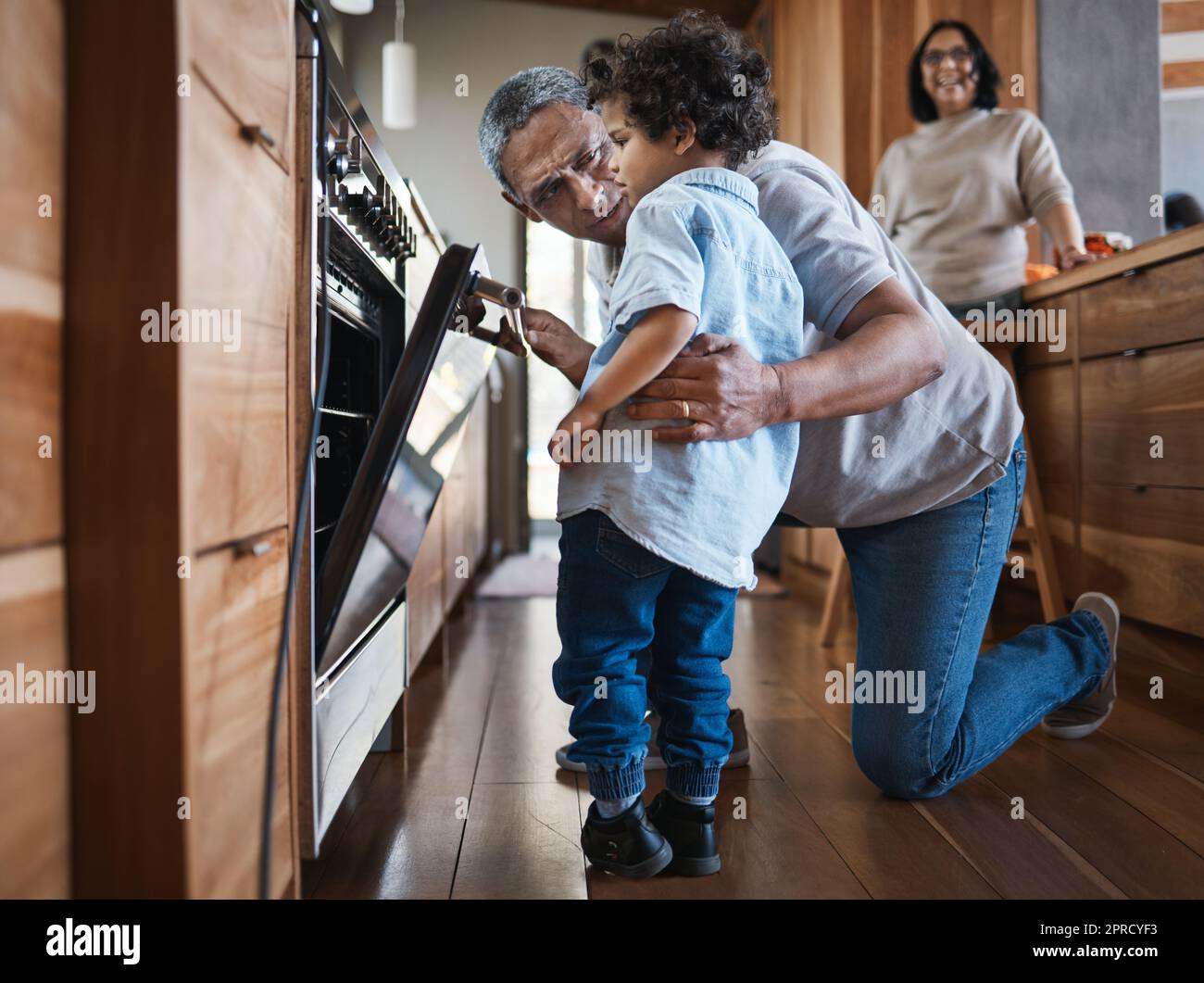 Ein älterer Mann, der mit seinem Enkelkind in der Küche backt, während er sich mit Liebe, Fürsorge und Glück verbindet. Kochen, Familienzeit und alter Mann in Stockfoto