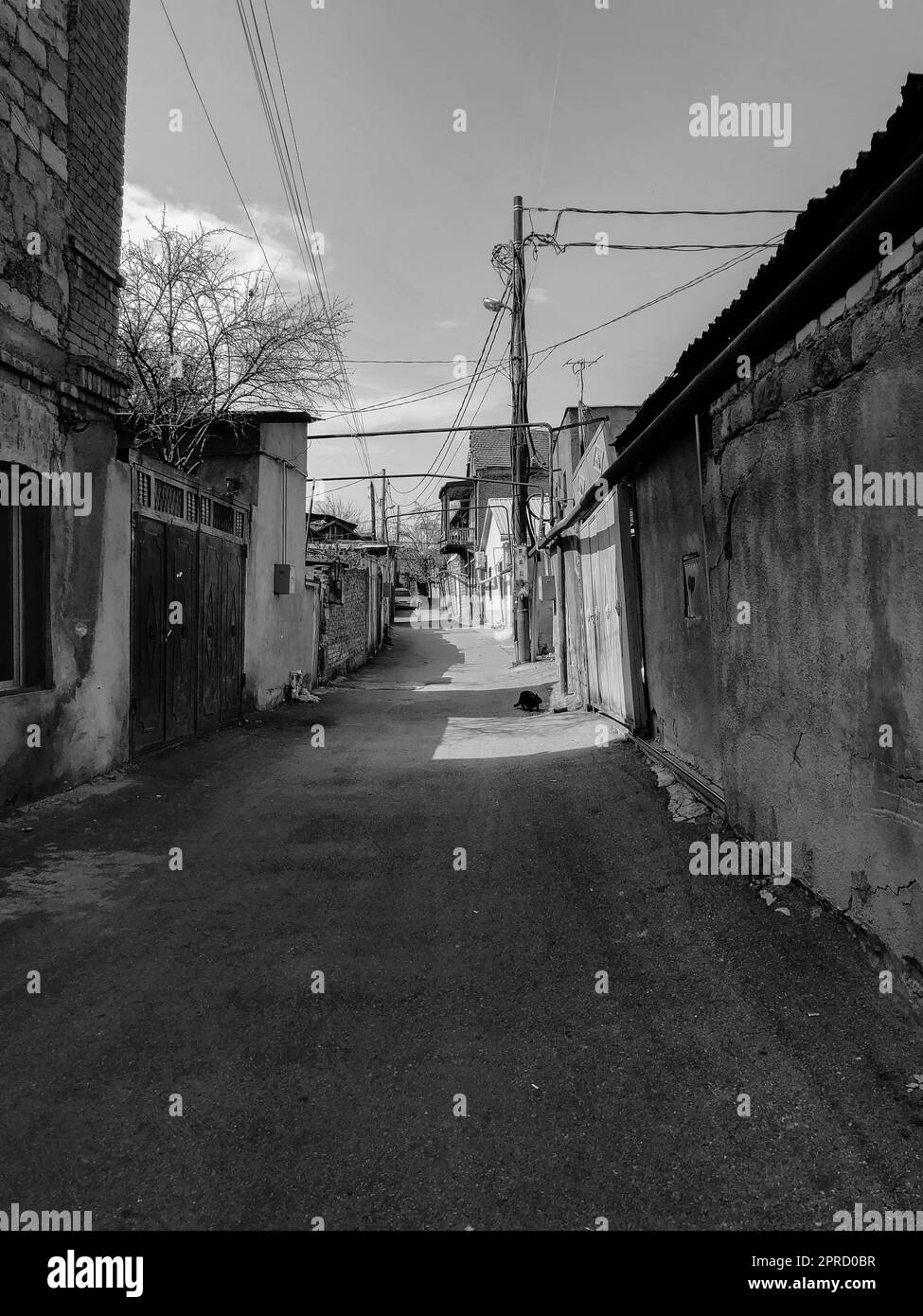 Enge Straße, Gasse, Tunnel mit alten Häusern, Gebäude an den Seiten in einer armen Gegend der Stadt, Slums. Vertikales Foto. Stockfoto
