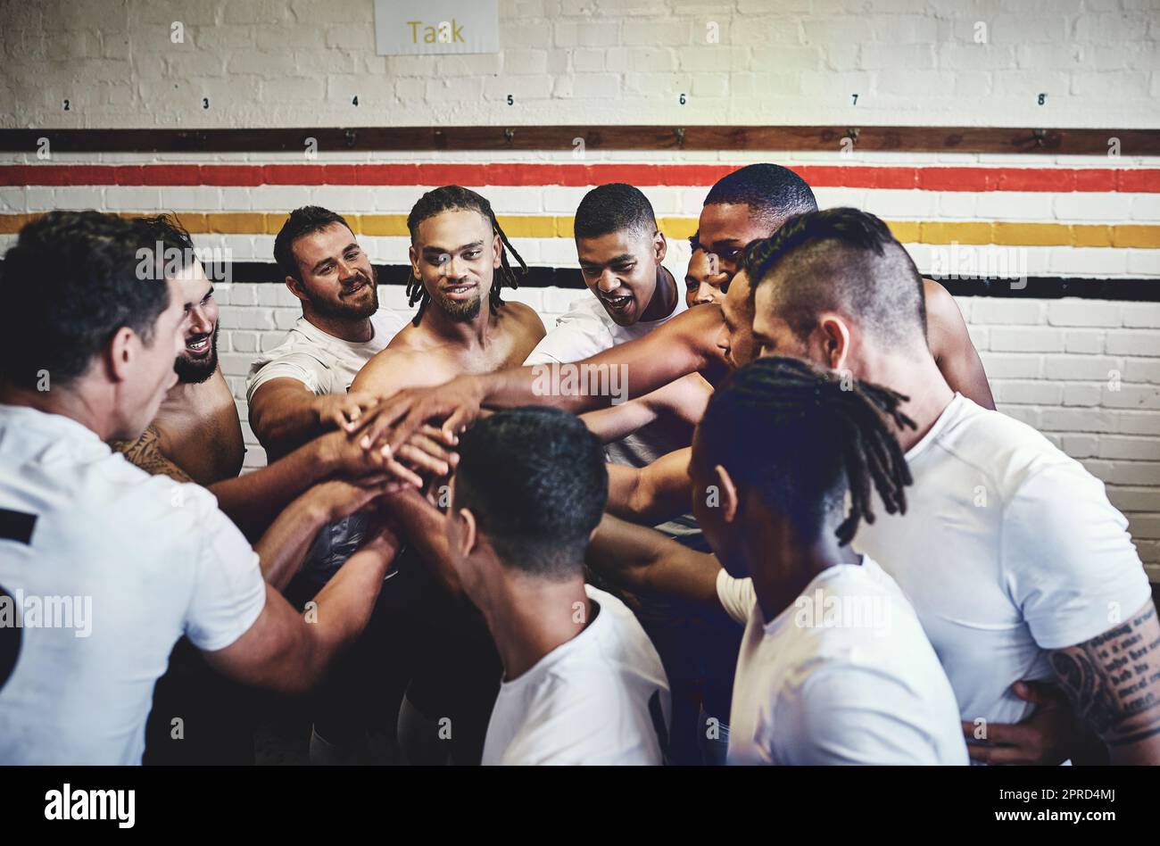 Die Gruppe der Champions. Eine Gruppe hübscher junger Rugby-Spieler, die in einer Umkleidekabine zusammenstehen. Stockfoto