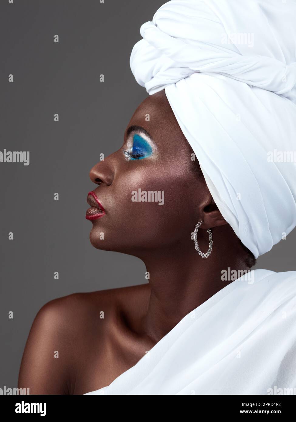 Tradition ist immer im Trend. Studioaufnahme einer attraktiven jungen Frau, die in traditioneller afrikanischer Kleidung vor grauem Hintergrund posiert. Stockfoto