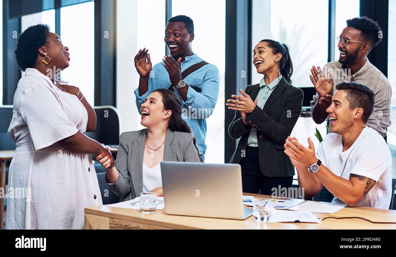 Wir bewunderten immer Ihre harte Arbeit und Ihr Engagement. Eine Gruppe von Geschäftsleuten applaudiert ihren Kollegen in einem Büro. Stockfoto