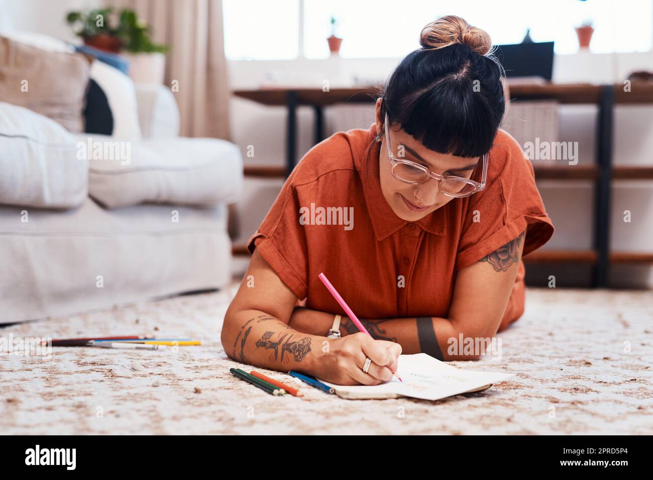 Genießen Sie eine gute Stress-Relief-Sitzung. Eine junge Frau mit Malstiften, während zu Hause zeichnen. Stockfoto