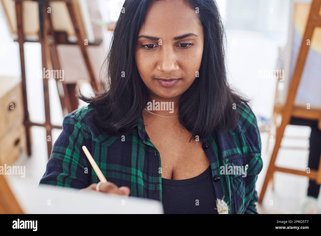 Vergiss alles andere und beginne zu kreieren. Eine schöne junge Frau malt in einem Kunststudio. Stockfoto