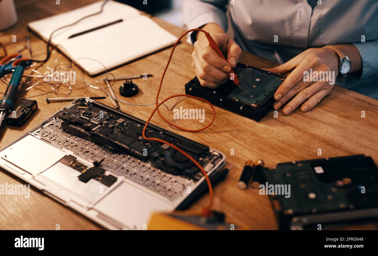 Bei der Festsetzung einer Festplatte geht es um das Speichern der Daten. Eine unkenntliche Computertechnikerin repariert eine Festplatte in ihrer Werkstatt. Stockfoto