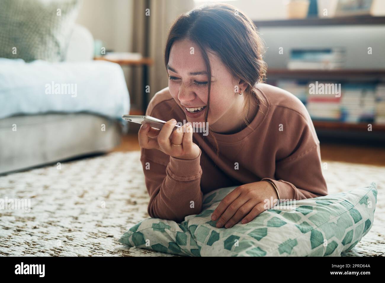 Man weiß nie, wer Sie sagen hören muss Hallo. eine junge Frau mit einem Smartphone, während Sie sich zu Hause entspannen. Stockfoto