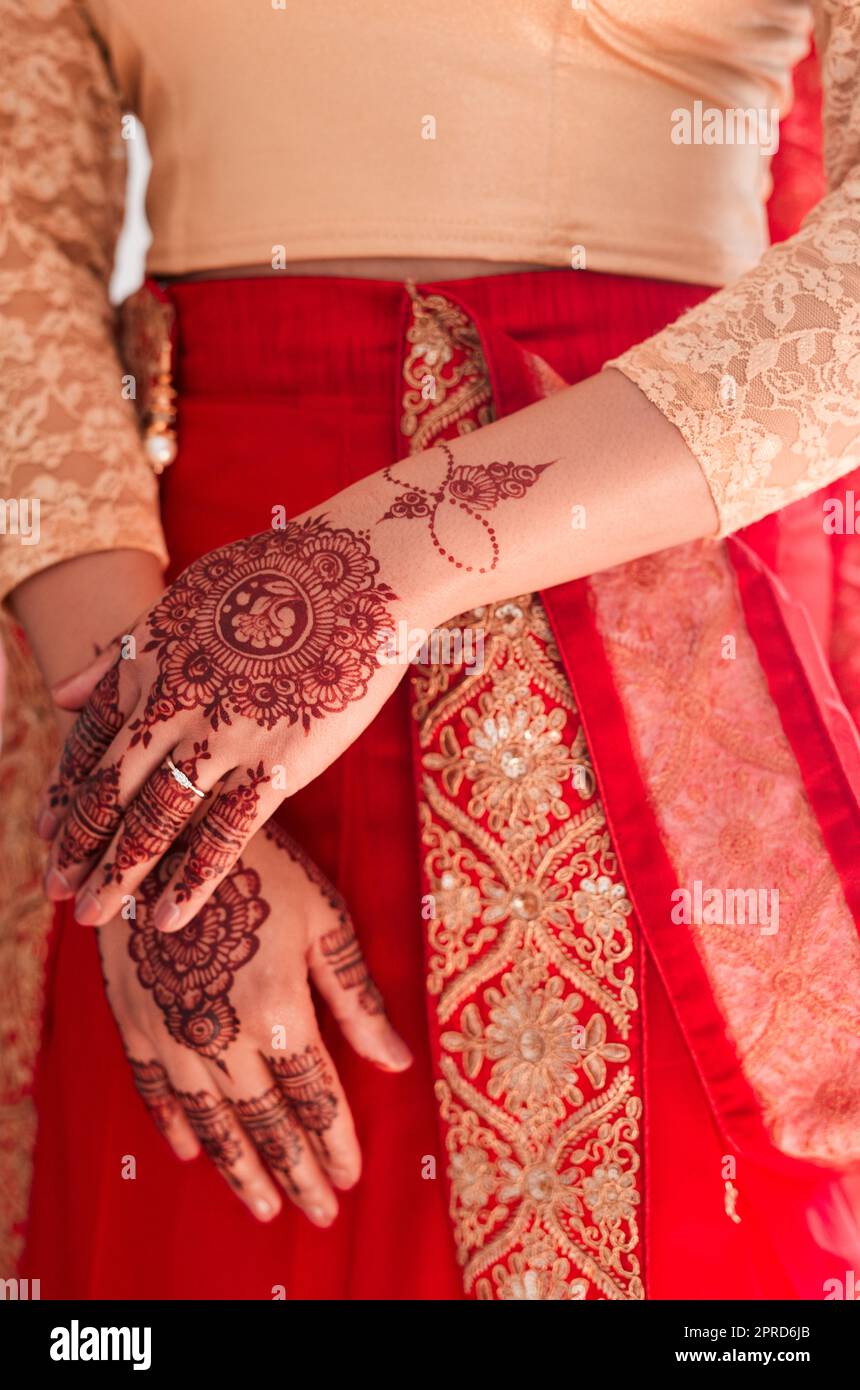 Jede Kultur hat ihre eigenen Bräuche. Eine unverkennbare Frau mit Mehendi, die an ihrem Hochzeitstag auf die Hände gemalt wurde. Stockfoto