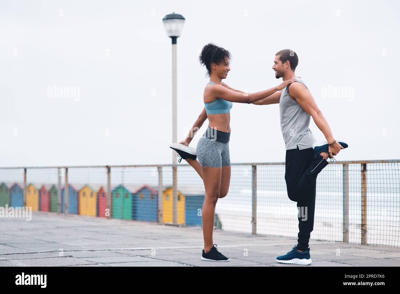 Für die beste Unterstützung können wir uns aufeinander verlassen. Zwei sportliche junge Menschen dehnen sich beim Training im Freien. Stockfoto