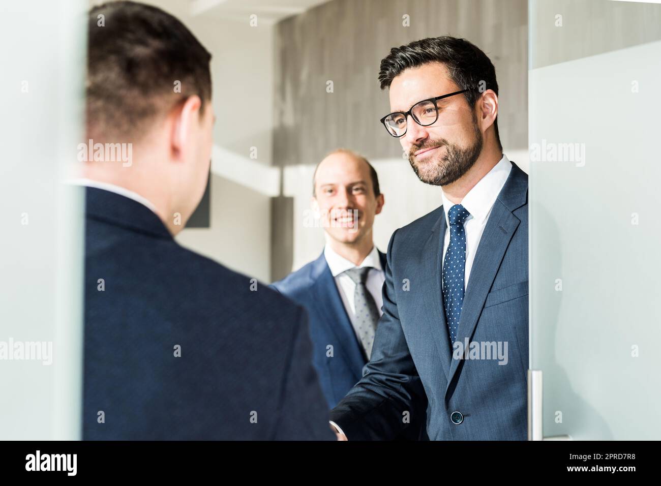 Eine Gruppe selbstbewusster Geschäftsleute grüßt bei Geschäftstreffen in modernen Büros mit einem Handschlag oder schließt die Vereinbarung, indem sie die Hände schütteln. Stockfoto