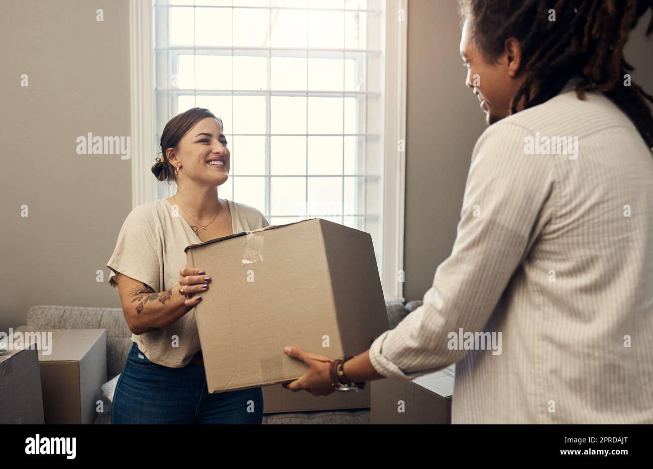 Ill tun alle schweren Heben für Sie. Ein glückliches junges Paar in ihr neues Zuhause ziehen. Stockfoto