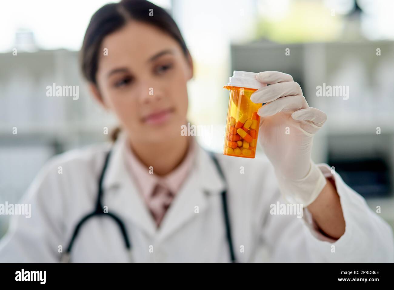 Eine Heilung, die funktioniert. Ein junger Mediziner hält eine Flasche Pillen in einem Labor. Stockfoto