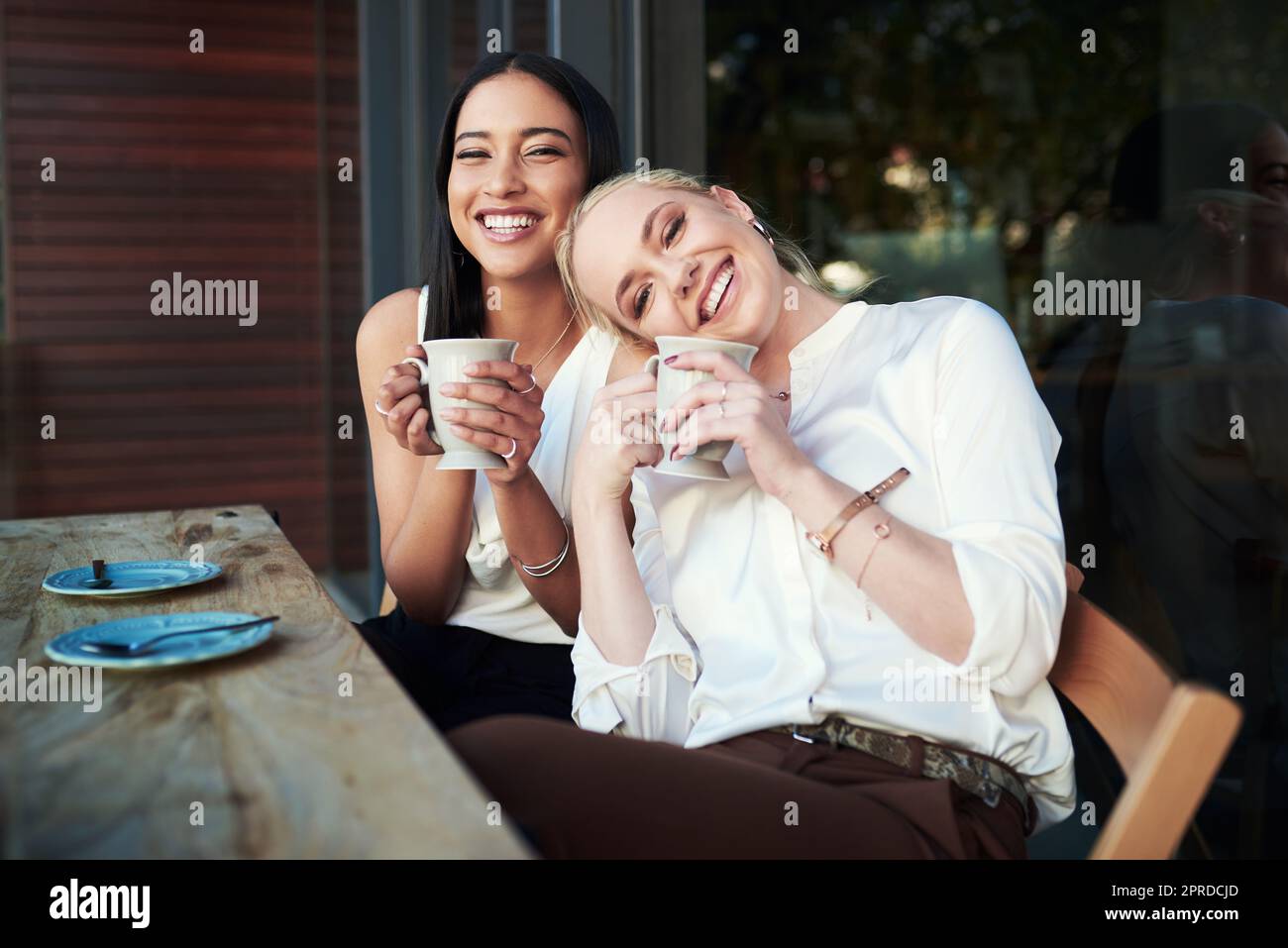 Alles, was Sie brauchen, ist ein guter Freund und guter Kaffee. Zwei junge Frau genießen einander Gesellschaft beim Kaffee in einem Café. Stockfoto