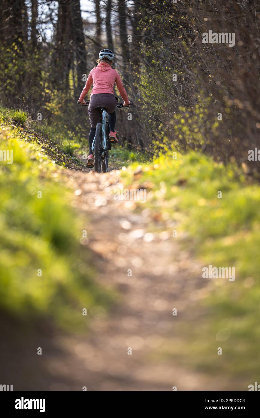 Hübsche, junge Frau mit ihrem Mountainbike, die die Stadtgrenzen überschreitet und die tägliche Dosis Cardio erhält Stockfoto