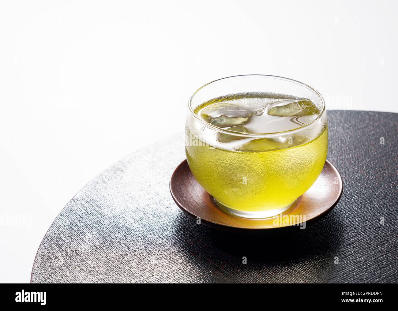 Kalter japanischer grüner Tee auf einem schwarzen Tablett. Grüner Tee mit Eis. Stockfoto