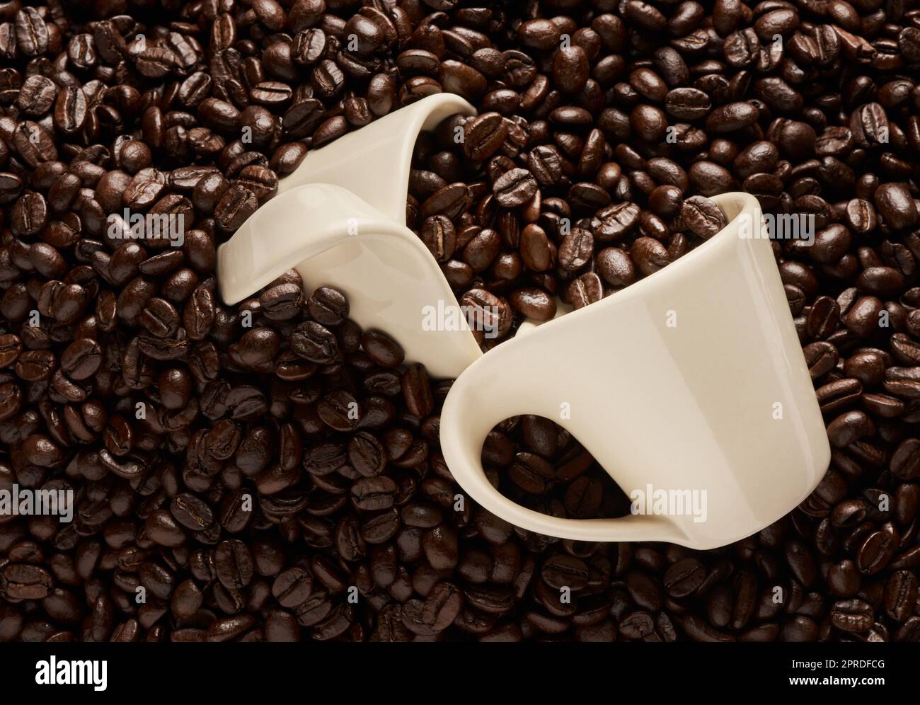 Kaffee verbessert Ihre Stimmung. Nahaufnahme von zwei Tassen auf einem Stapel Kaffeebohnen. Stockfoto