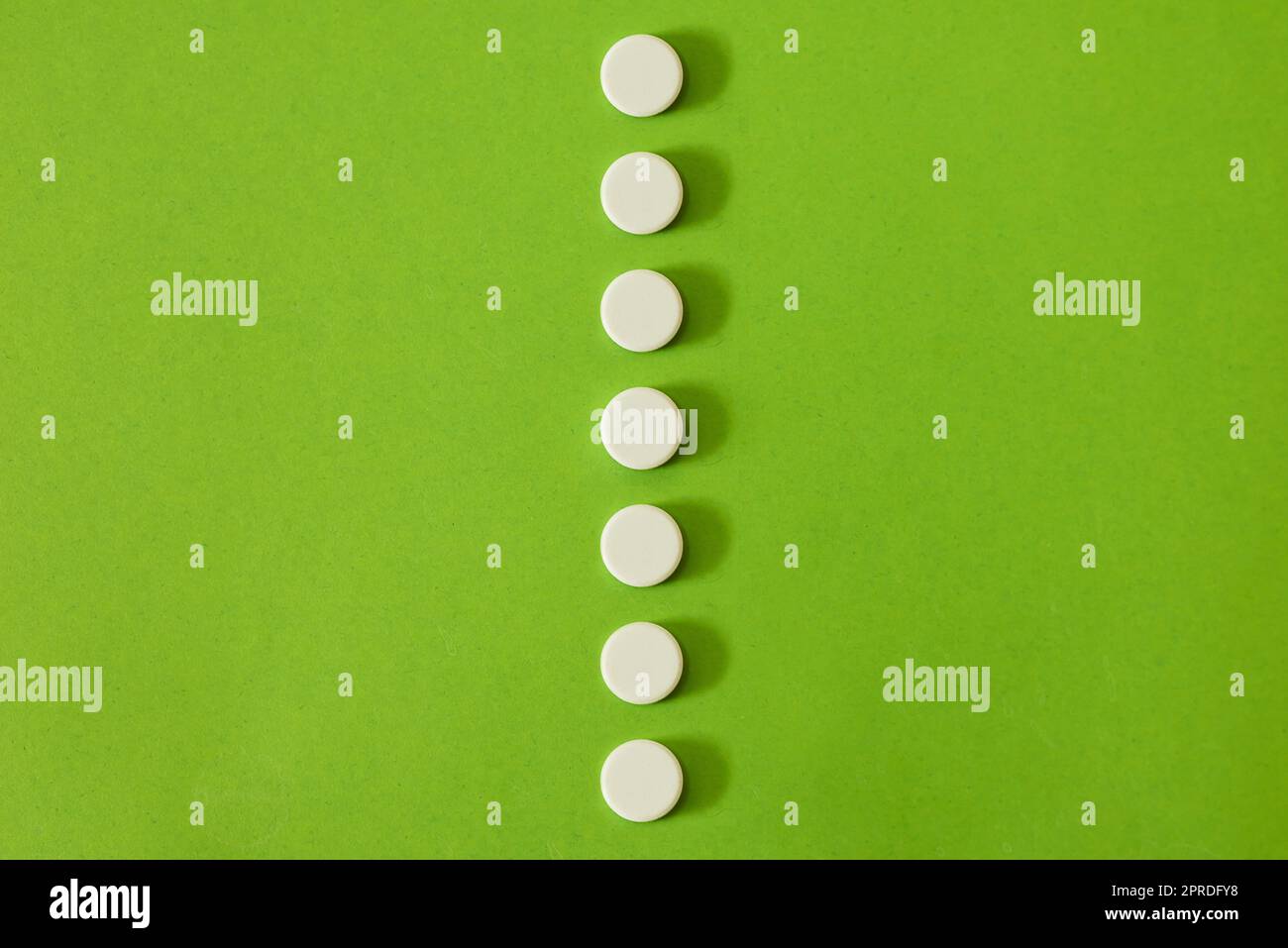 Diese halten Sie auf der geraden und schmalen. Studioaufnahme einer Reihe weißer Tablets vor grünem Hintergrund. Stockfoto