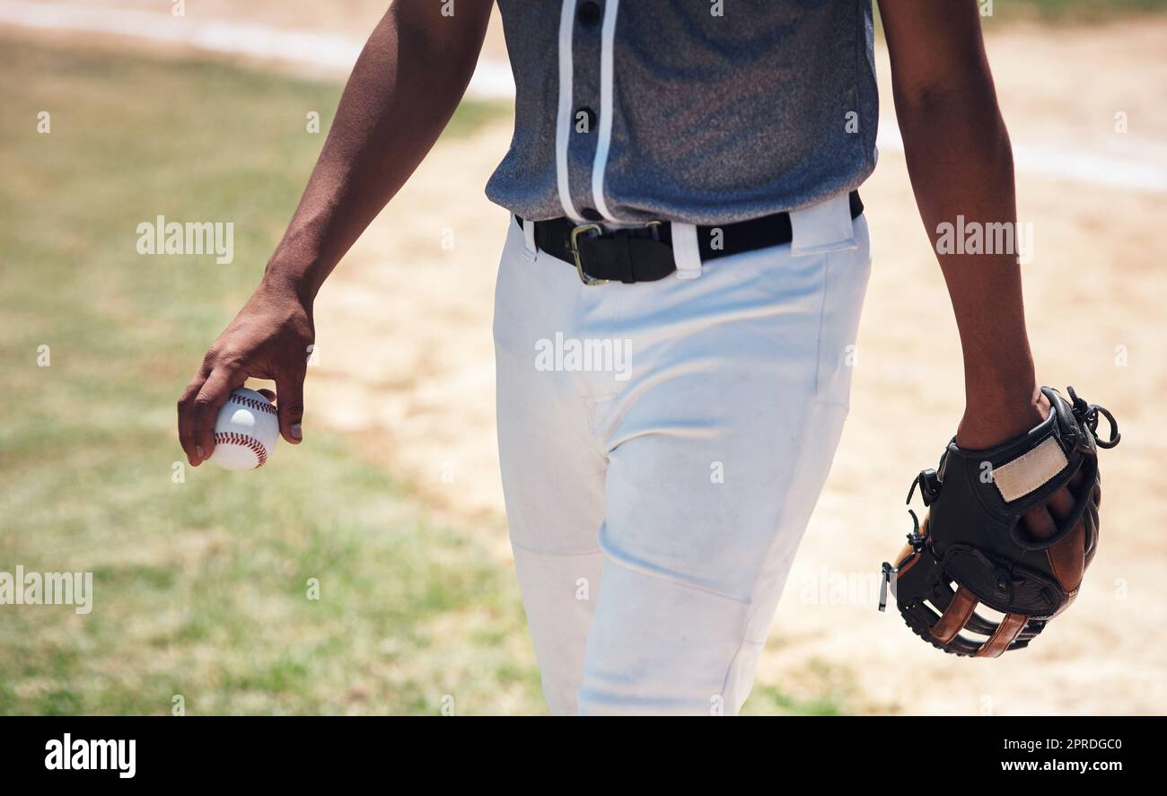 Wer den Ball hält, ist Boss. Ein Mann steht auf einem Feld und hält einen Baseballhandschuh und Ball bei einem Spiel. Stockfoto