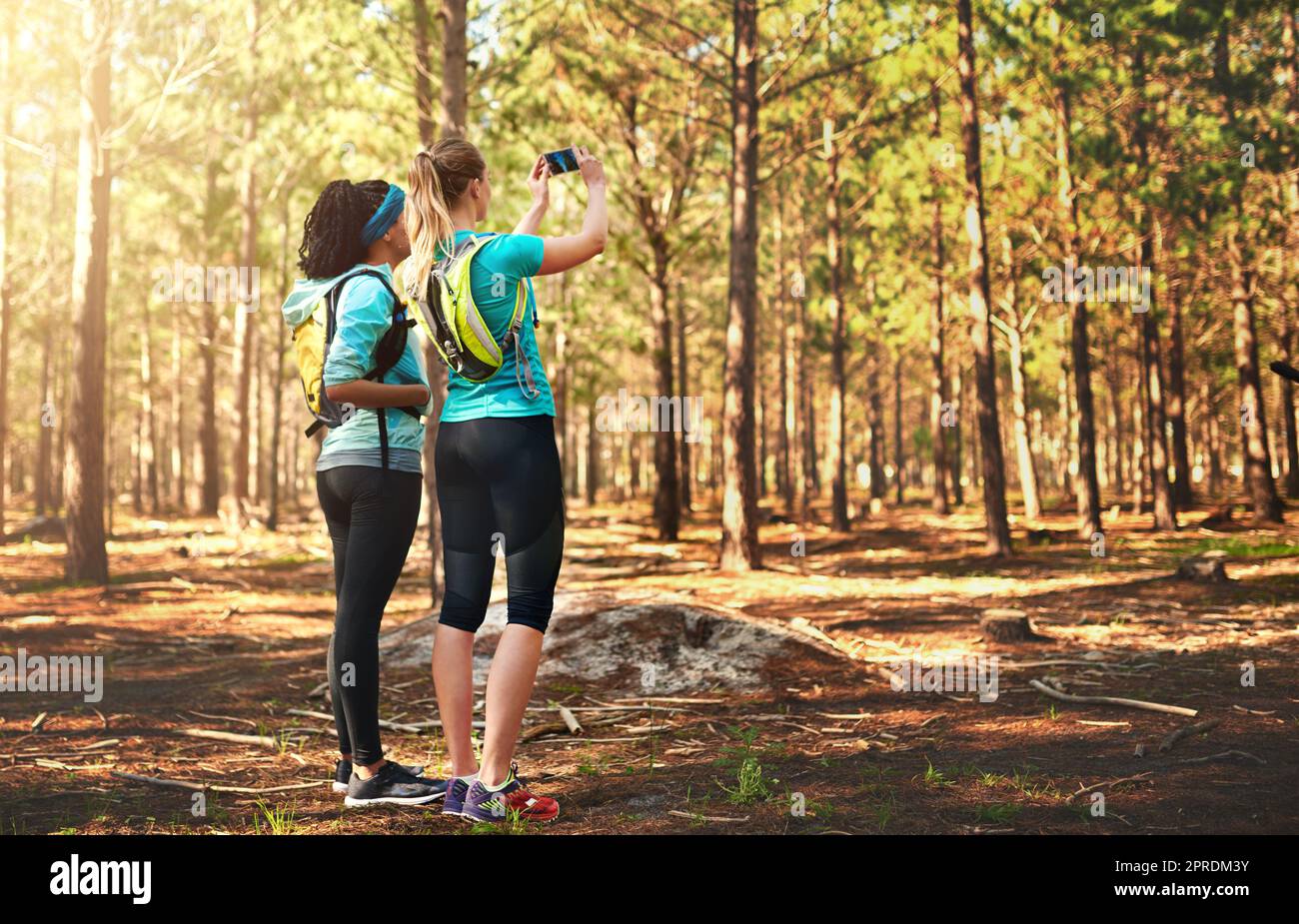 Nehmen Sie nichts als Erinnerungen mit. Zwei sportliche junge Frau, die in der Natur fotografiert. Stockfoto