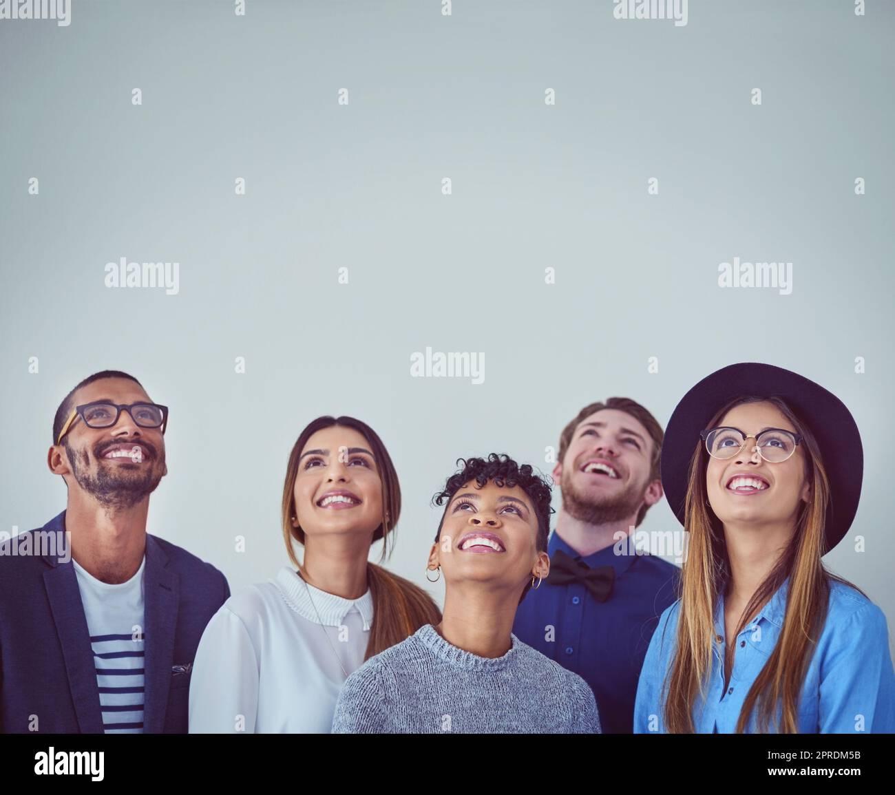 Blick in die Zukunft. Studio-Aufnahme einer Gruppe junger Geschäftsleute, die vor grauem Hintergrund aufblicken. Stockfoto