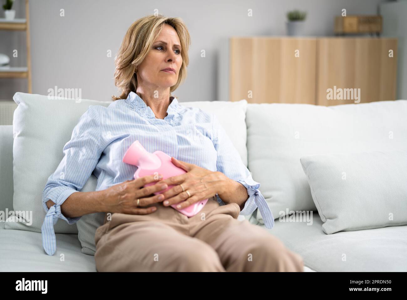 Frau mit Magen Schmerzen beim Liegen auf dem Sofa Stockfoto
