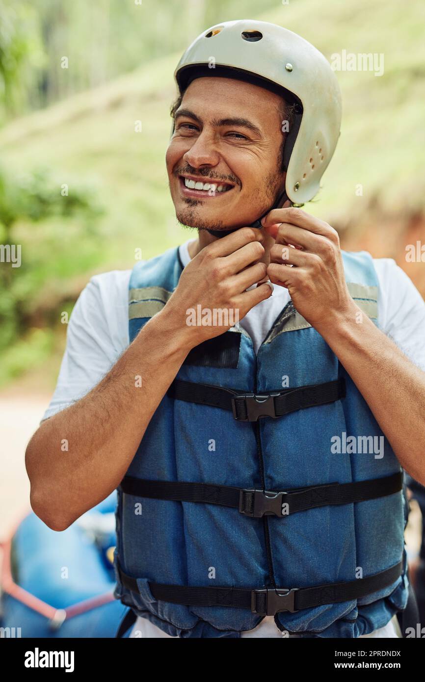 Du lebst nur einmal, also mach das Beste daraus. Ein junger Mann, der seinen Helm justiert. Stockfoto