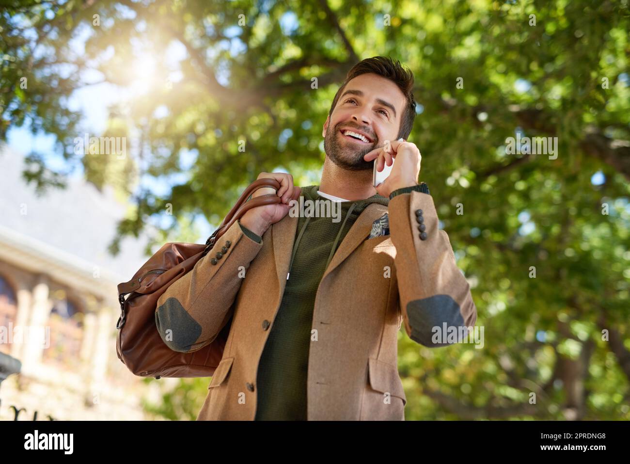Ja, ich bin gerade auf dem Weg nach draußen. Ein hübscher junger Mann, der während seines morgendlichen Pendelvorgangs einen Telefonanruf ablegt. Stockfoto