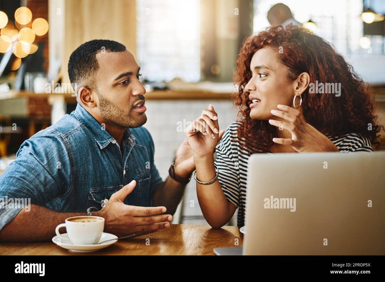 Offene Kommunikationswege. Ein junges Paar, das in einem Café an einem Laptop arbeitet. Stockfoto