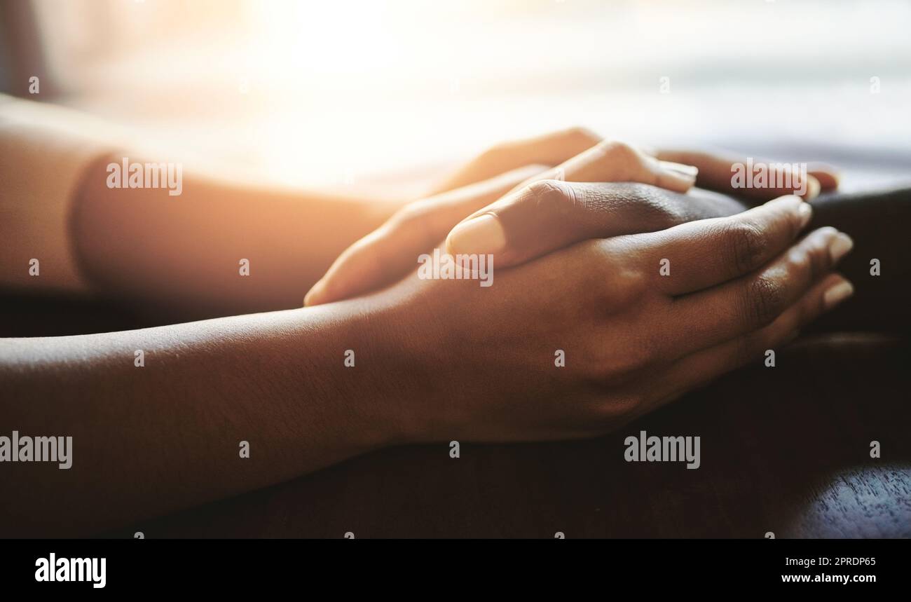 Ein Paar beruhigt, stützt und hält Hände auf einem Tisch. Ein afrikanischer Mann und eine afrikanische Frau, die Liebe, Mitgefühl und Romantik in einer Geste der Fürsorge zeigen. Menschliche Verbindung durch Berührung hilft bei Trauer. Stockfoto