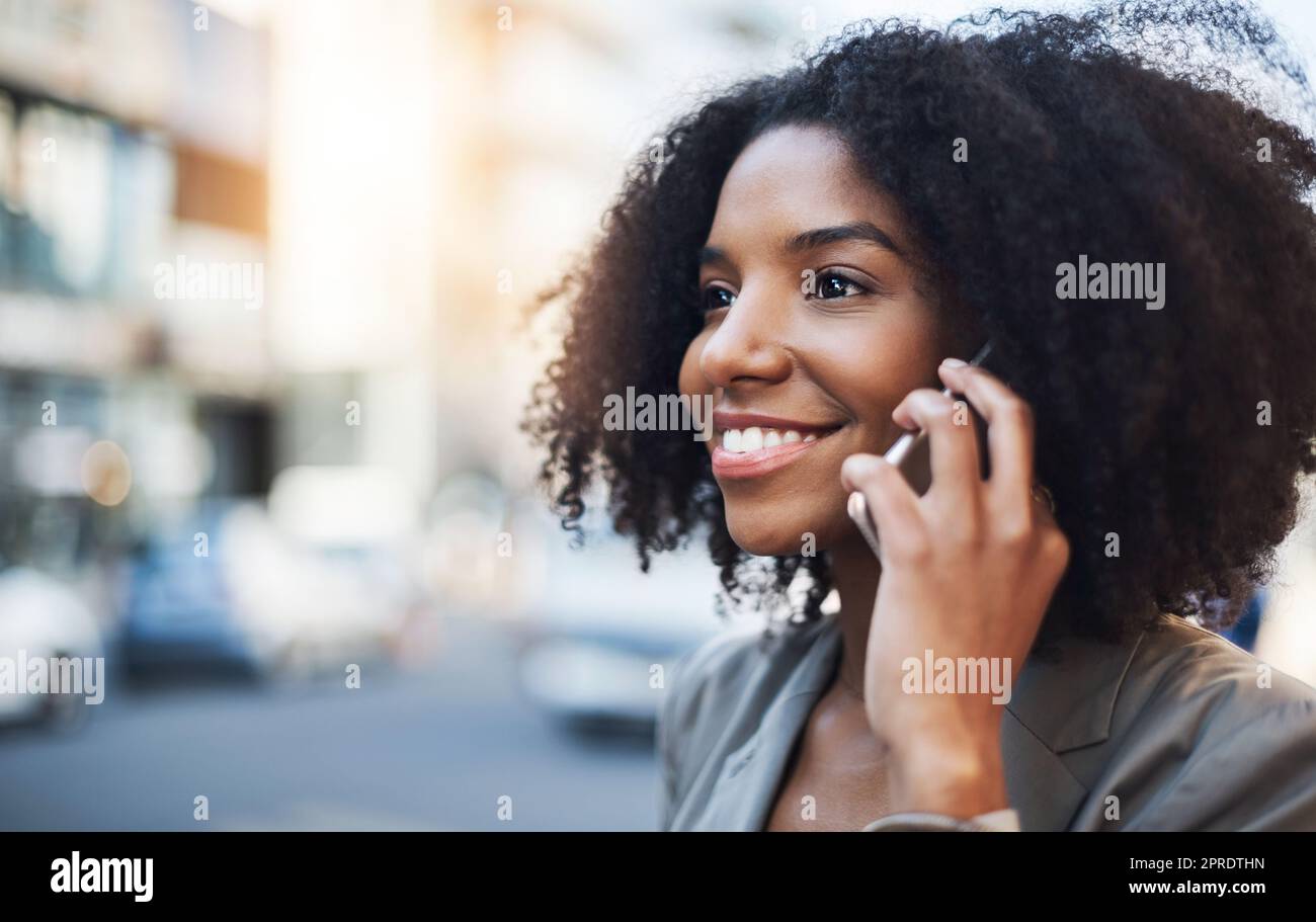 Shes frei, Geschäfte zu jeder Zeit zu sprechen. Eine junge Geschäftsfrau im Gespräch auf einem Handy in der Stadt. Stockfoto