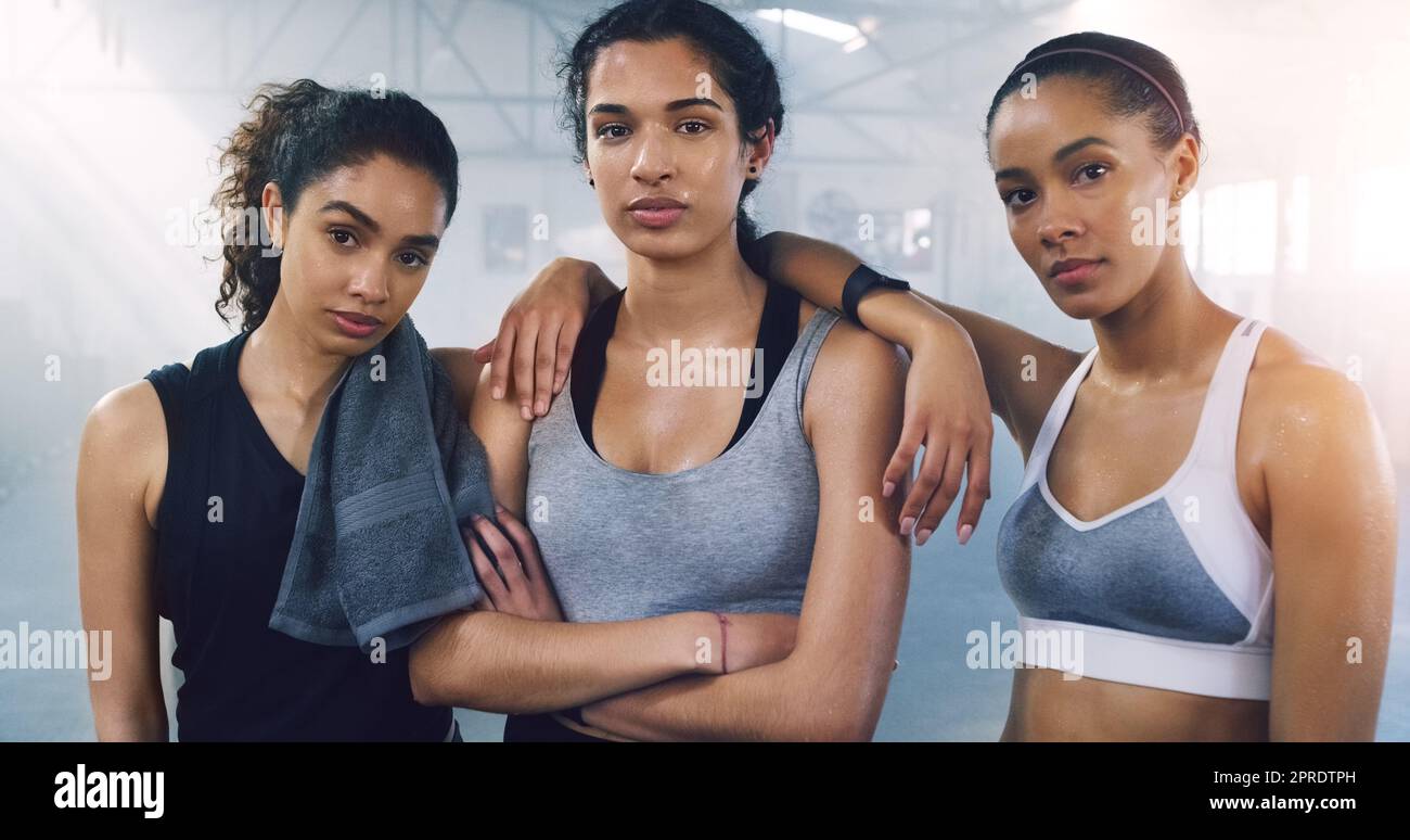 Wenn du sie nicht schlagen kannst, schließe dich ihnen an. Porträt von drei jungen Sportlerinnen, die in der Turnhalle stehen und posieren. Stockfoto