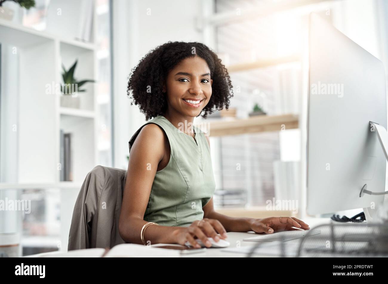 Meine Karriere ist auf dem richtigen Weg. Eine junge Geschäftsfrau, die an ihrem Schreibtisch in einem modernen Büro arbeitet. Stockfoto