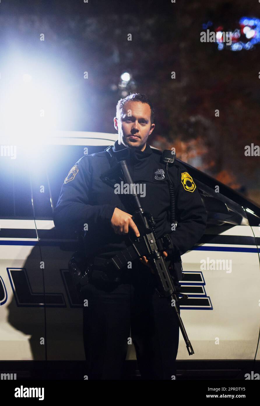 Zu dienen und zu schützen, unabhängig von den Kosten. Beschnittenes Porträt eines hübschen jungen Polizisten, der mit seinem Sturmgewehr auf der Patrouille steht. Stockfoto