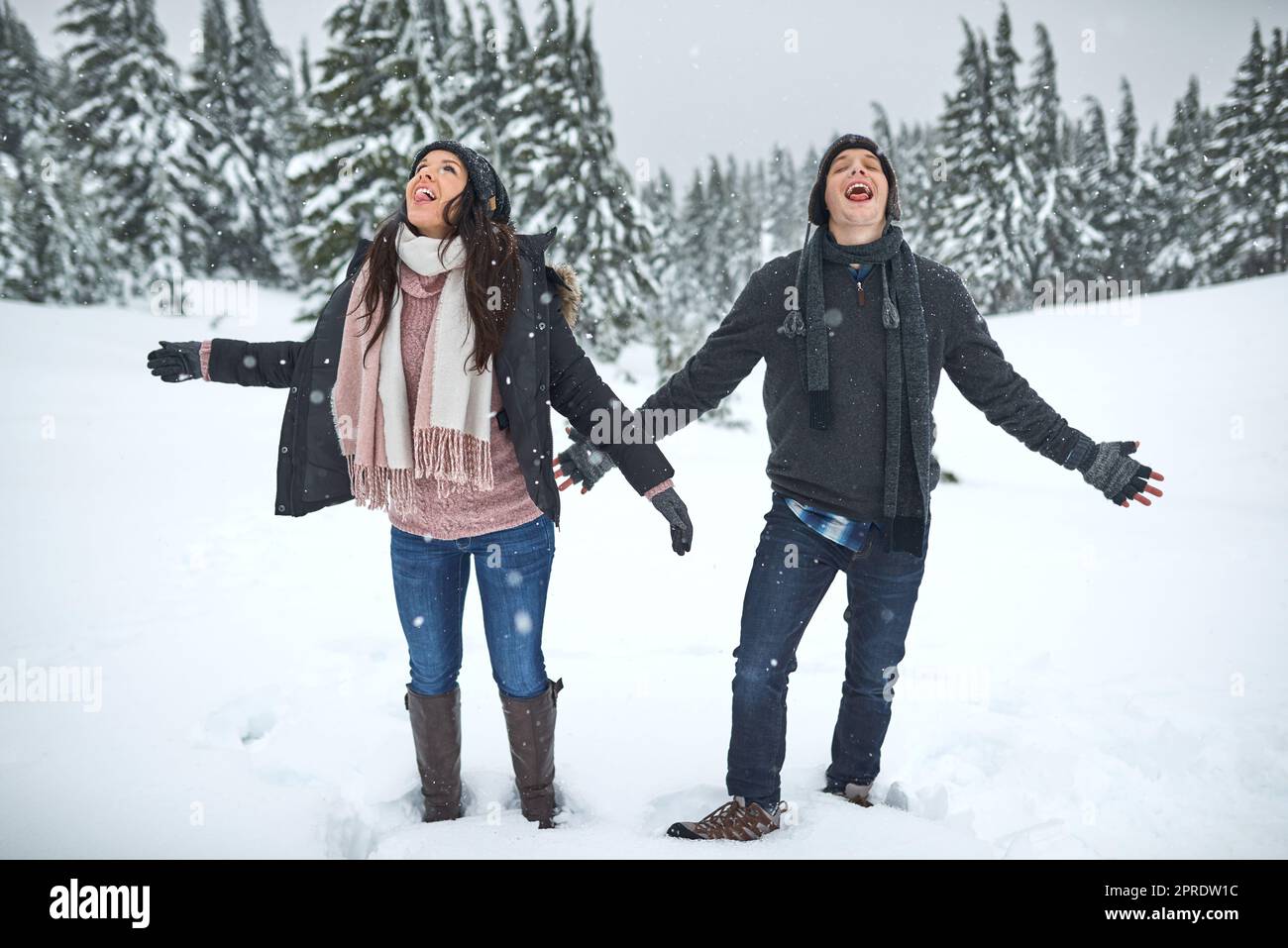 Gehen Sie dorthin, wo Sie sich am lebendigsten fühlen. Ein glückliches junges Paar genießt sich, während Sie draußen im Schnee sind. Stockfoto