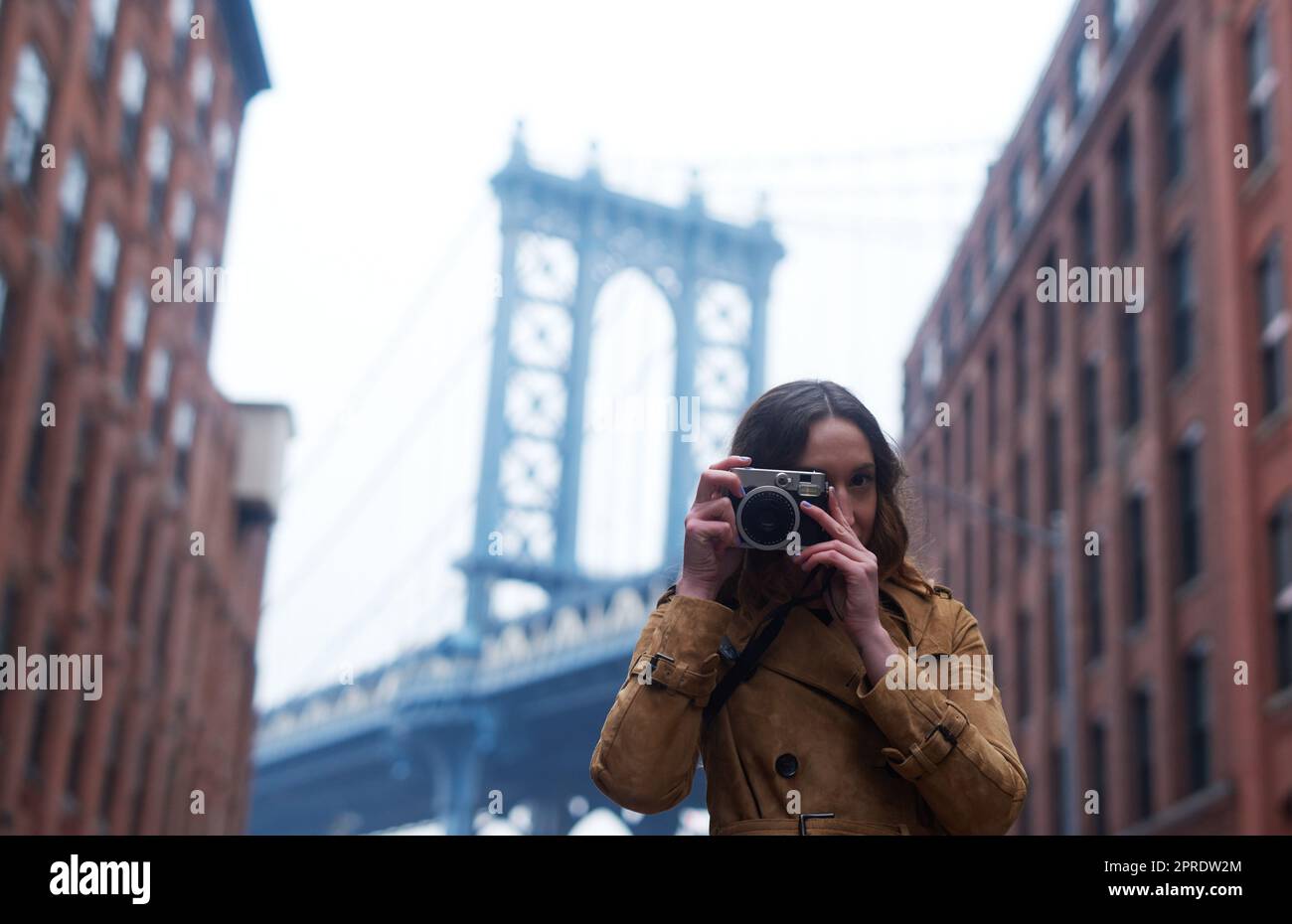 Verpassen Sie keinen einzigen Speicher mehr. Porträt einer attraktiven jungen Frau, die mit einer Kamera in der Stadt fotografiert. Stockfoto