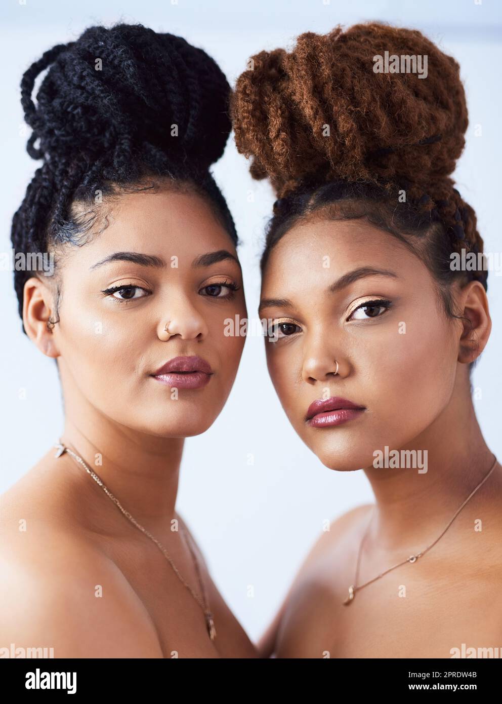 Haare zurück und sieht wunderschön aus. Studioaufnahme von zwei schönen jungen Frauen, die vor einem grauen Hintergrund posieren. Stockfoto