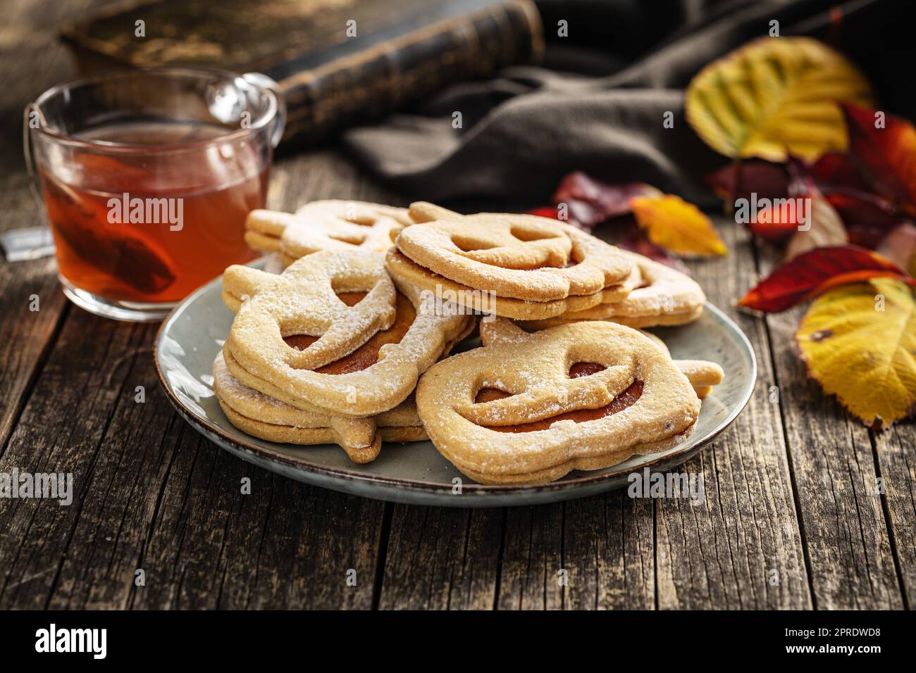 Linzer Kekse in Form eines Halloween Kürbisses auf dem Holztisch. Stockfoto