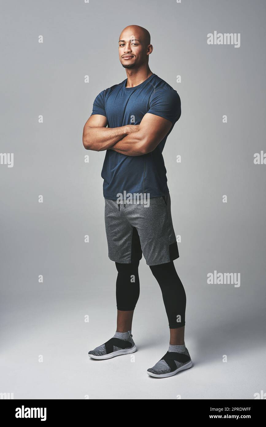 Fitter zu werden beginnt mit einer Entscheidung. Studioporträt eines athletischen jungen Mannes, der mit gekreuzten Armen vor grauem Hintergrund steht. Stockfoto
