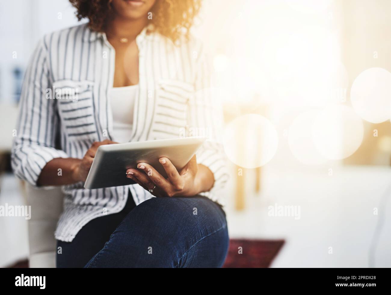Geschäftsfrau, die auf einem Tablet tippt, auf E-Mails antwortet und Benachrichtigungen abfragt, während sie im Büro sitzt. Manager, Facharbeiter und kreativer Designer suchen im Internet nach Ideen Stockfoto