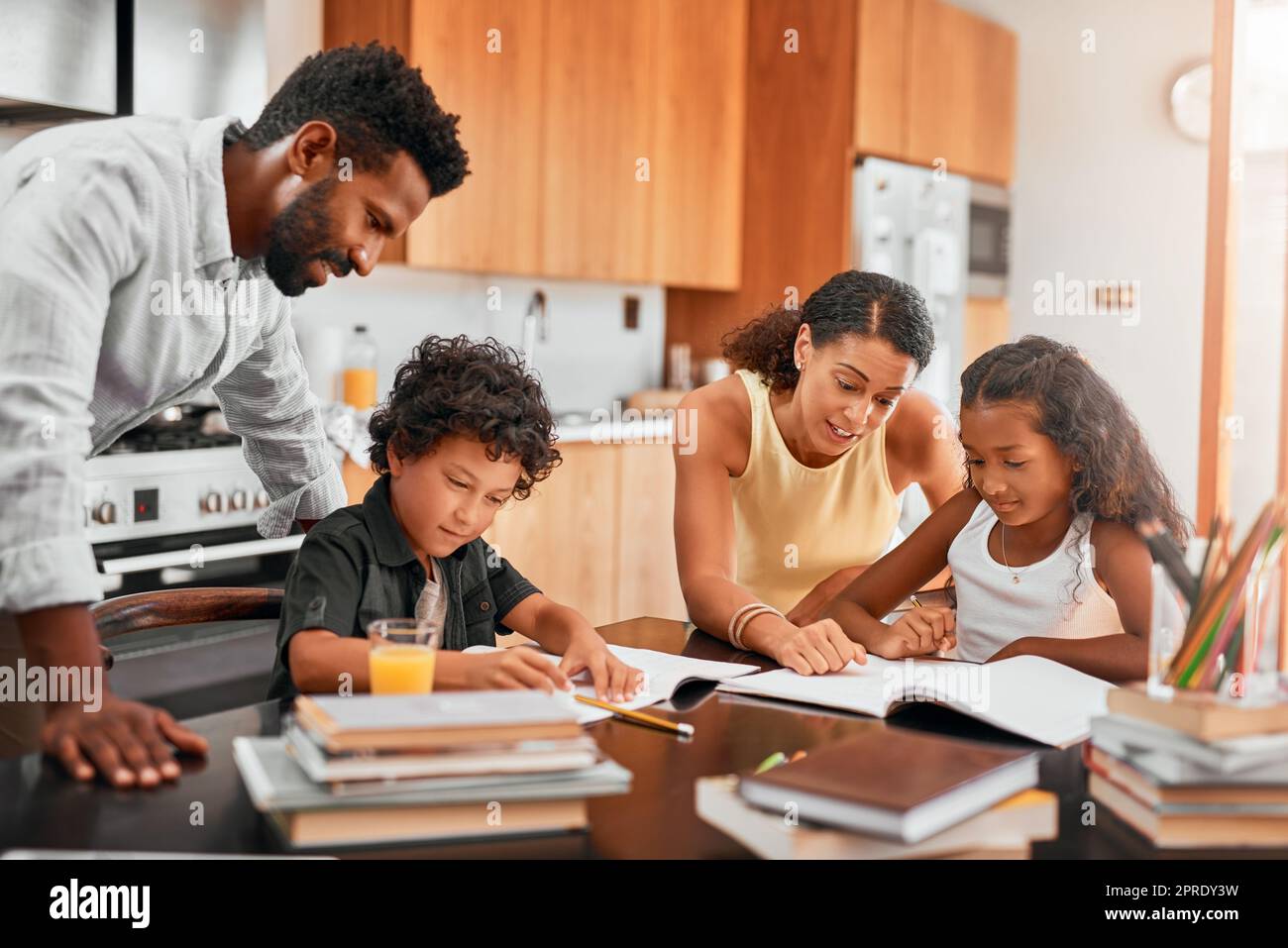 Spielen Sie eine aktive Rolle in Ihren Kindern Hausaufgaben. Eltern helfen ihren beiden Kindern bei ihren Hausaufgaben. Stockfoto