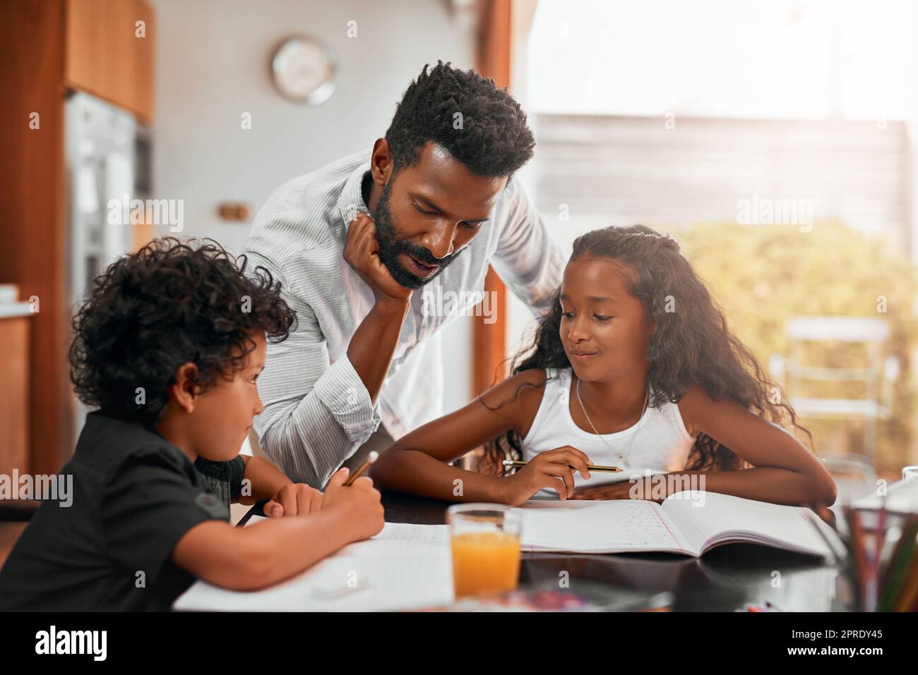 Seine Hausaufgaben Stunde. Ein Vater hilft seinen Kindern bei ihren Hausaufgaben. Stockfoto