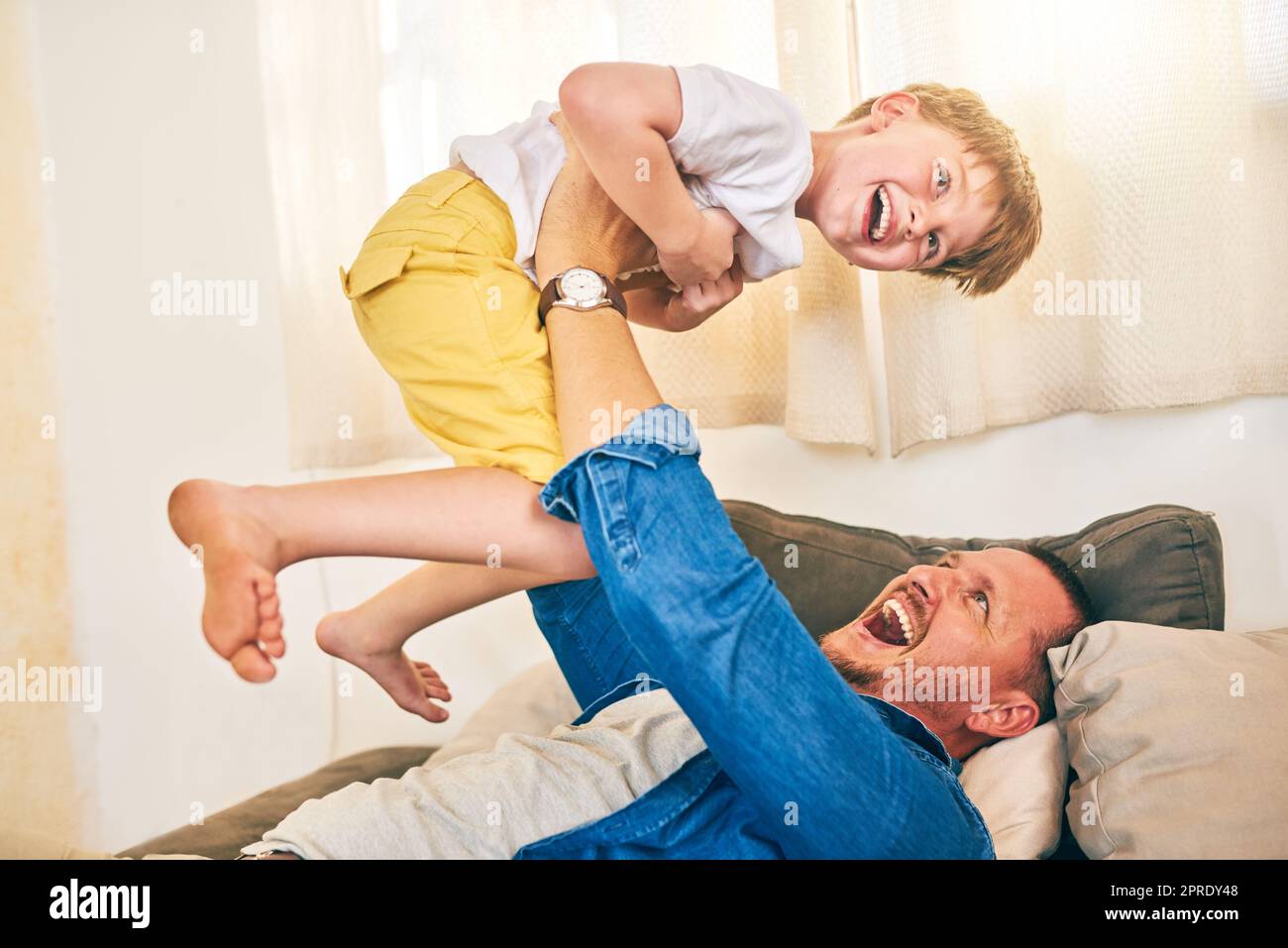 Mehr als Spielzeit, seine Bindungszeit. Ein glücklicher kleiner Junge, der Spaß mit seinem Vater zu Hause hat. Stockfoto