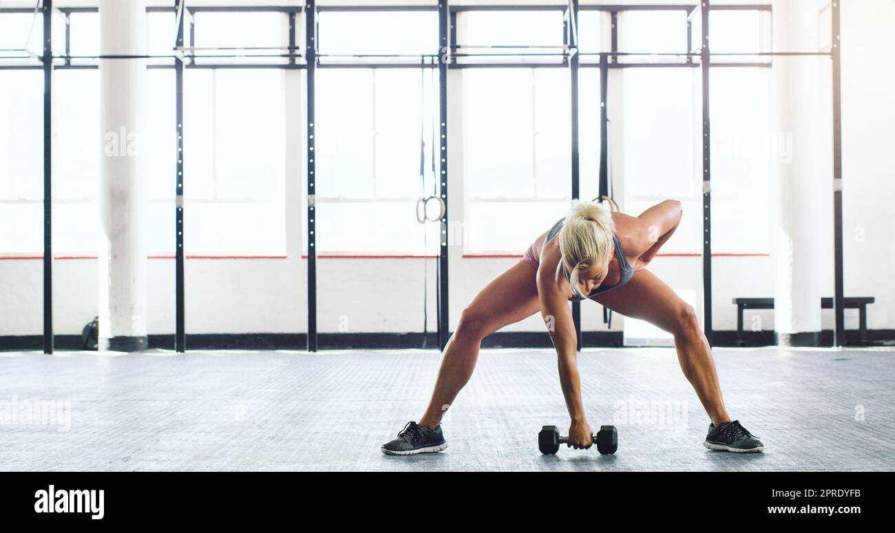 Werden Sie stark, Sie Schulden es sich. Eine junge Frau mit Gewichten in einem Fitnessstudio trainieren. Stockfoto