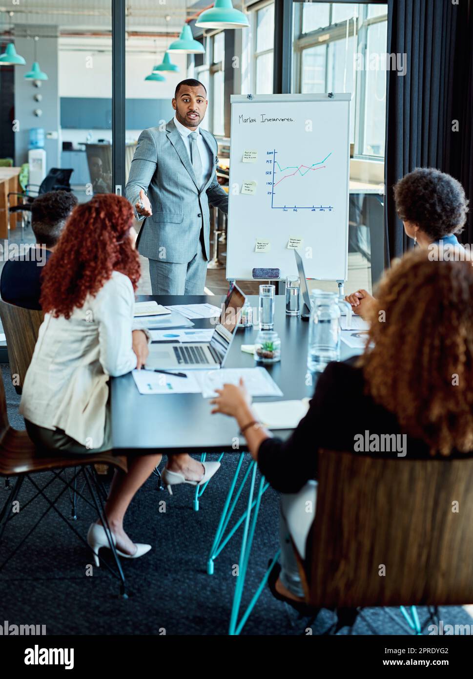 Zusammenarbeit mit dem Team bei seinen großen Plänen. Ein Geschäftsmann, der seinen Kollegen in einem Sitzungssaal eine Präsentation gibt. Stockfoto