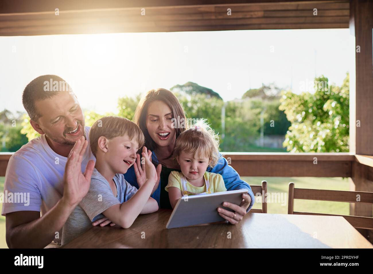 Eine Familie, die im Ausland einen Videoanruf auf einem digitalen Tablet macht. Stockfoto