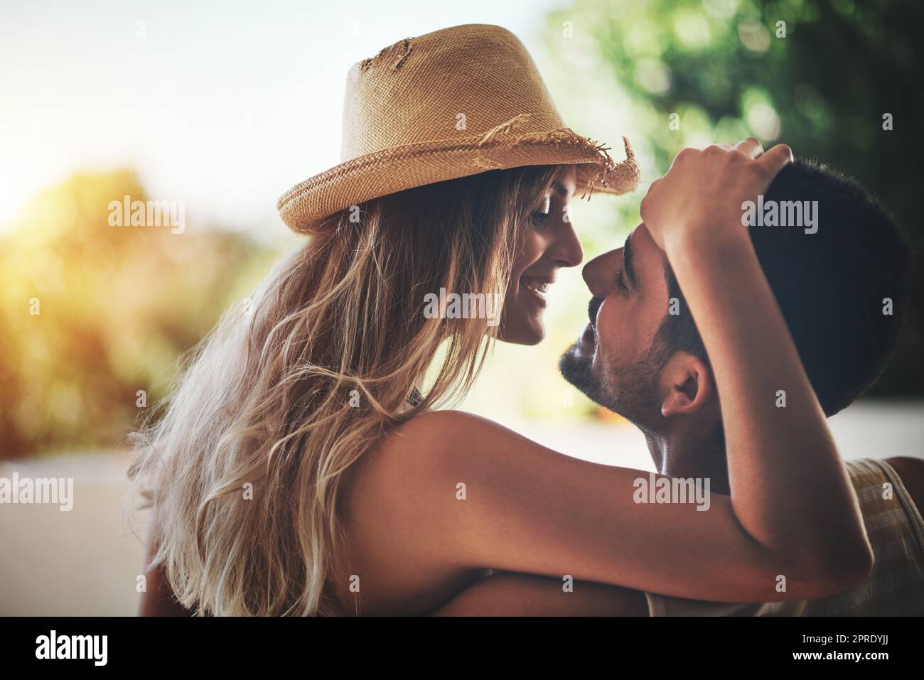 Genießen Sie jeden Moment. Ein liebevolles junges Paar, das einen intimen Moment draußen auf ihrem Balkon teilt. Stockfoto